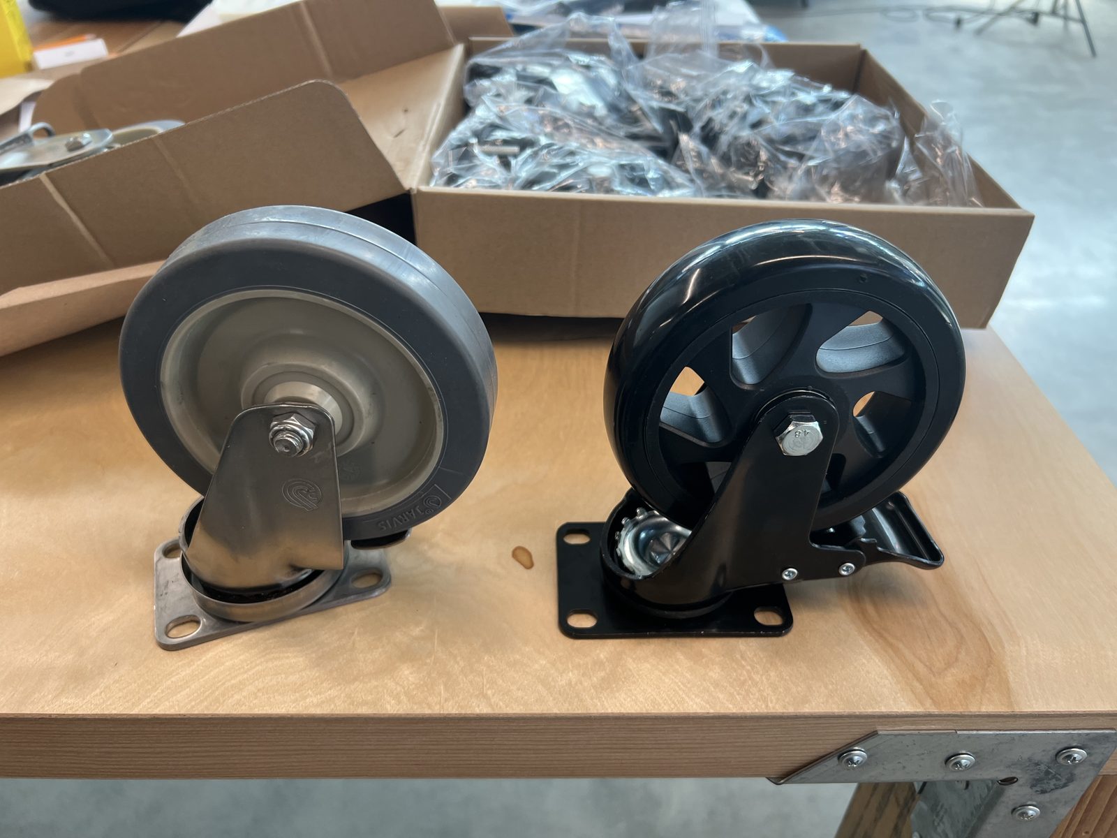 Two candidate casters side by side on a workbench